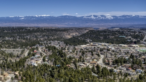 DXP002_134_0003 - Aerial stock photo of A view of distant mountains seen from homes near mesas and canyons in Los Alamos, New Mexico