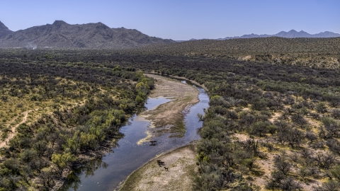DXP002_141_0002 - Aerial stock photo of Horses at a shallow river in the desert
