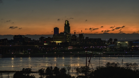 DXP002_173_0001 - Aerial stock photo of A view over the river toward the skyline at twilight, Downtown Omaha, Nebraska