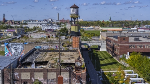 DXP002_194_0013 - Aerial stock photo of A water tower atop an abandoned brick building in Detroit, Michigan