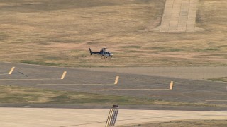 AF0001_000012 - HD aerial stock footage track helicopter coming in for a landing at small airport, Central Valley, California