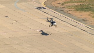 AF0001_000014 - HD aerial stock footage track a helicopter landing at airport in the Central Valley, California