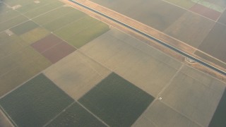 AF0001_000074 - HD stock footage aerial video of a bird's eye view of farmland, California Aqueduct, and light clouds, Central Valley, California