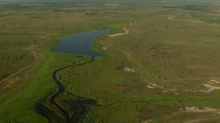 AF0001_000207 - HD aerial stock footage of dirt roads and a pond in the countryside, Matagorda County, Texas
