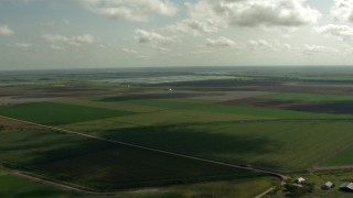 AF0001_000224 - HD aerial stock footage of flying over farmland to approach fish farms, Danevang, Texas