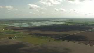 AF0001_000225 - HD aerial stock footage of flying over farm fields and approach fish farms, Danevang, Texas