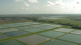 AF0001_000226 - HD aerial stock footage of flying over fields and fish farms, Danevang, Texas