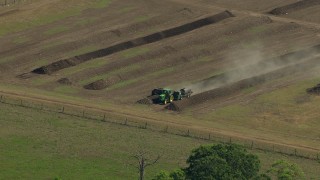 AF0001_000232 - HD aerial stock footage approach a tractor working a farm field in Wharton County, Texas