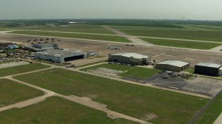 AF0001_000301 - HD aerial stock footage flyby hangars with a view of helicopters and jet at Ellington Airport, Houston, Texas