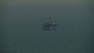 AF0001_000343 - HD aerial stock footage of an oil derrick in the Gulf of Mexico at sunrise