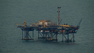 AF0001_000346 - HD aerial stock footage of an oil rig at sunrise in the Gulf of Mexico