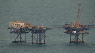 AF0001_000348 - HD aerial stock footage of part of a large oil derrick at sunrise in the Gulf of Mexico