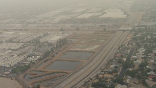 AF0001_000361 - HD aerial stock footage flyby homes by Pacoima Wash and 210 Freeway, tilt to warehouses, San Fernando, California