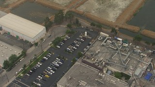 AF0001_000362 - HD aerial stock footage of warehouses and a parking lot, San Fernando, California
