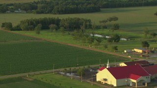 AF0001_000450 - HD aerial stock footage flyby small rural church and crop fields at sunset, Gulf Coast, Alabama