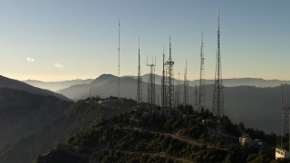 AF0001_000491 - HD aerial stock footage orbit radio towers on Mount Wilson, San Gabriel Mountains, California, sunset