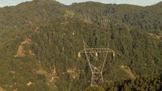 AF0001_000500 - HD aerial stock footage follow power lines up a mountain in the San Gabriel Mountains, California, sunset