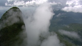 AF0001_000583 - HD aerial stock footage orbit a green mountain peak shrouded in misty clouds in Southern Venezuela
