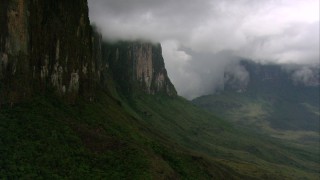 AF0001_000606 - HD aerial stock footage tilt from a bird's eye of jungle and pan to reveal steep mountain cliffs in Southern Venezuela