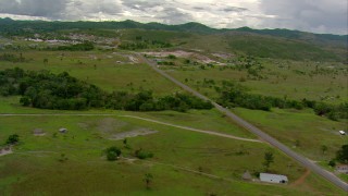 AF0001_000675 - HD stock footage aerial video of rural homes and farms by a country highway near a small town in Southern Venezuela