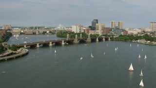 AF0001_000784 - HD aerial stock footage fly over sailboats to approach the Longfellow Bridge as a commuter train crossing, Boston, Massachusetts