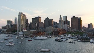 AF0001_000788 - HD aerial stock footage flyby boats in the marina and skyscrapers in Downtown Boston, Massachusetts, sunset