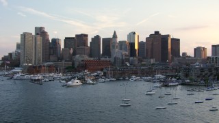 AF0001_000791 - HD aerial stock footage of the city skyline and marina seen from the Charles River, Downtown Boston, Massachusetts, sunset