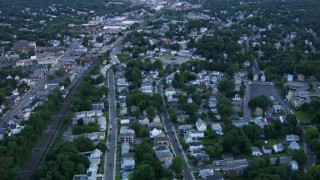 AF0001_000813 - HD aerial stock footage of flying over a residential neighborhood by train tracks in Hyde Park, Massachusetts, twilight