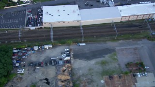 AF0001_000814 - HD aerial stock footage of a commuter train passing through Hyde Park, Massachusetts, twilight