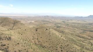 AF0001_000872 - HD aerial stock footage fly over Mae West Peaks to approach a quarry near Dragoon, Arizona