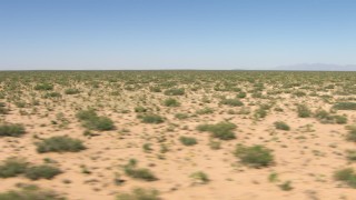 AF0001_000905 - HD aerial stock footage of passing desert vegetation on a wide desert plain in New Mexico