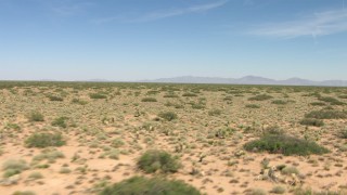 AF0001_000907 - HD stock footage aerial video pan across a wide desert plain in New Mexico