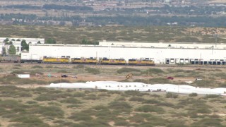 AF0001_000918 - HD stock footage aerial video of a train passing a warehouse in El Paso, Texas