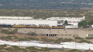 AF0001_000919 - HD stock footage aerial video of a train passing a large warehouse building in El Paso, Texas
