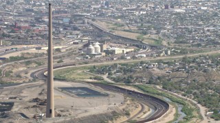 AF0001_000923 - HD stock footage aerial video of a smoke stack by Highway 85 and a small factory building in El Paso, Texas