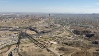 AF0001_000924 - HD aerial stock footage fly over a quarry and Highway 85 past smoke stacks to approach I-10 in El Paso, Texas