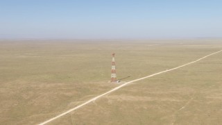 AF0001_000960 - HD stock footage aerial video approach a tower by a dirt road in a desert plain near El Paso, Texas