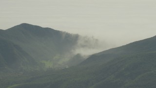 AF0001_000973 - 5K aerial stock footage of fog rolling over green mountains in Los Angeles, California