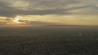 AF0001_000976 - 5K aerial stock footage of urban neighborhoods and Downtown Los Angeles skyline seen from Santa Fe Springs, California at sunset