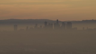 AF0001_000978 - 5K aerial stock footage of the Downtown Los Angeles skyline in haze at sunset, California