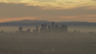 AF0001_000986 - 5K aerial stock footage of passing the Downtown Los Angeles skyline in haze at sunset, California
