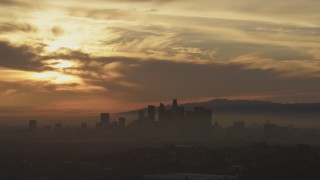 AF0001_000988 - 5K aerial stock footage of a view of sunset and clouds above the hazy Downtown Los Angeles skyline, California
