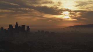 AF0001_000991 - 5K aerial stock footage of part of the hazy Downtown Los Angeles skyline at sunset, California