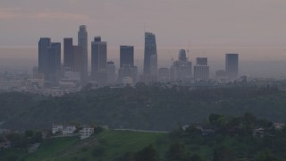 AF0001_000998 - 5K aerial stock footage of Downtown Los Angeles skyline seen while flying behind Dodger Stadium at twilight, California