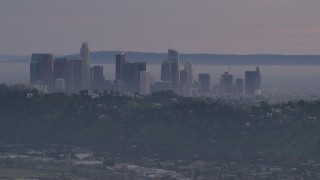 AF0001_001002 - 5K aerial stock footage of Downtown Los Angeles skyline behind hilltop Echo Park homes at twilight, California
