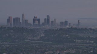 AF0001_001005 - 5K aerial stock footage of a view of Downtown Los Angeles skyline behind hillside houses in Silver Lake at twilight, California