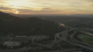 AF0001_001006 - 5K aerial stock footage of heavy traffic on the I-5/ 134 interchange and the Los Angeles River at sunset, Glendale, California