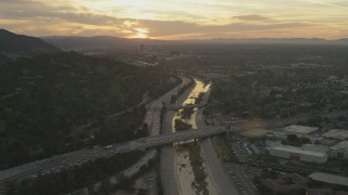 AF0001_001007 - 5K aerial stock footage of heavy traffic on 134 and I-5 by the Los Angeles River and neighborhoods at sunset, Burbank, California
