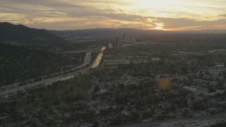 AF0001_001008 - 5K aerial stock footage of Los Angeles River, Highway 134, and neighborhoods at sunset, Burbank, California