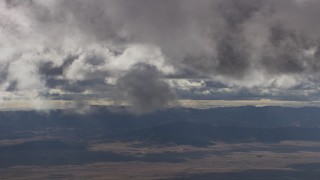 AF0001_001016 - 8K aerial stock footage of gray clouds over desert and mountain ridges in Southern California